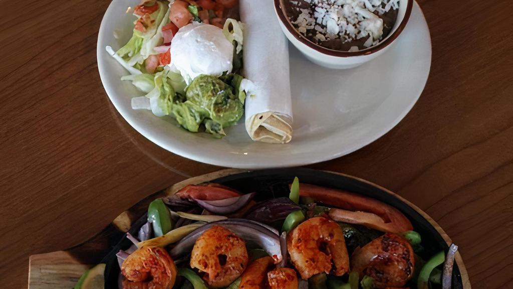 Shrimp Fajitas · Shrimp Sautéed in Guajillo Sauce with Sautéed Bell peppers, onions and tomatoes on a hot skillet. Served with lettuce, Pico de Gallo, guacamole, sour cream, rice, beans, corn or flour tortilla