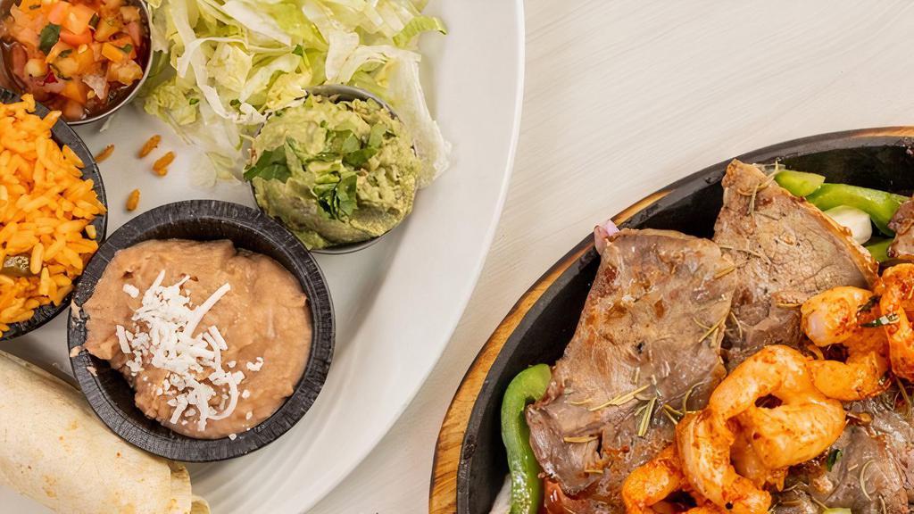 Surf N’ Turf Combo Fajitas · Sautéed Bell peppers, onions and tomatoes on a hot skillet. Served with lettuce, Pico de Gallo, guacamole, sour cream, rice, beans, corn or flour tortilla.