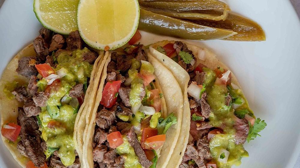 Taco Dinner · Three tacos on corn tortillas, choice of steak, ground beef, chicken, Al Pastor or veggie with side of rice and beans.