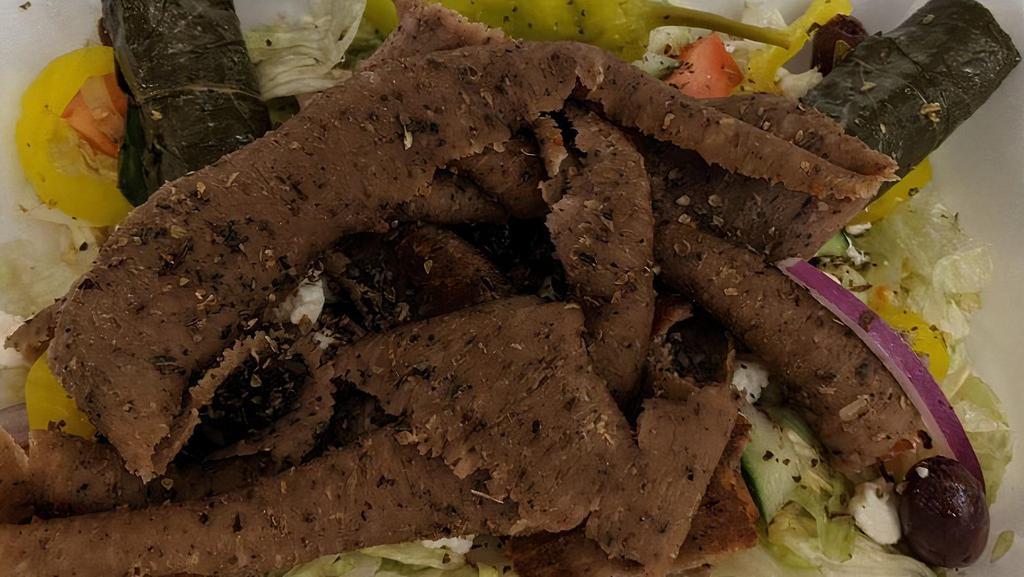 Greek Gyro Salad · Lamb, lettuce, onion, tomato, banana pepper, olives, cucumber, feta cheese, 2 pieces of grape leaves, vinegar and olive oil sauce.