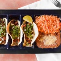 Tacos De Carne Asada · Three corn tortillas filled with grilled steak strips, served with a side of refried beans, ...