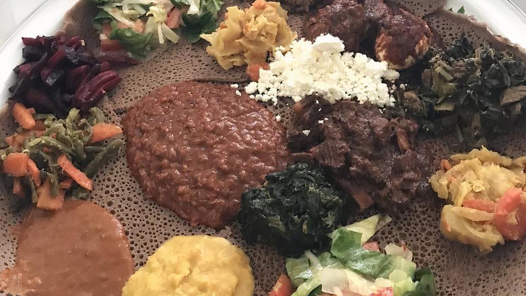 Vegetarian Combo/በየአይነቱ · A variety of vegan-friendly veggie dishes served on a bed of injera. Lentil and chickpea stew, cabbage, potato and carrot medley, Ethiopian style collard greens and a green bean and carrot stir fry.