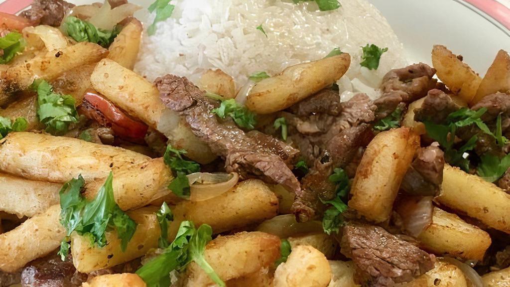Lomo Saltado Entrée · A traditional Peruvian dish that comes with pan-seared beef, tomatoes, onions + French Fries, and Rice.