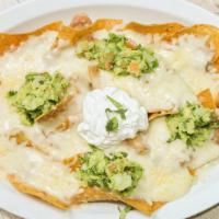 Nachos · A bed of crunchy tortilla chips caked in melted cheese with beans, cheese, sour cream and gu...