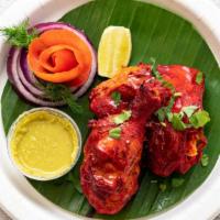 Tandoori Chicken · Chicken leg and thigh pieces are marinated overnight in yogurt with herbs and spices and coo...