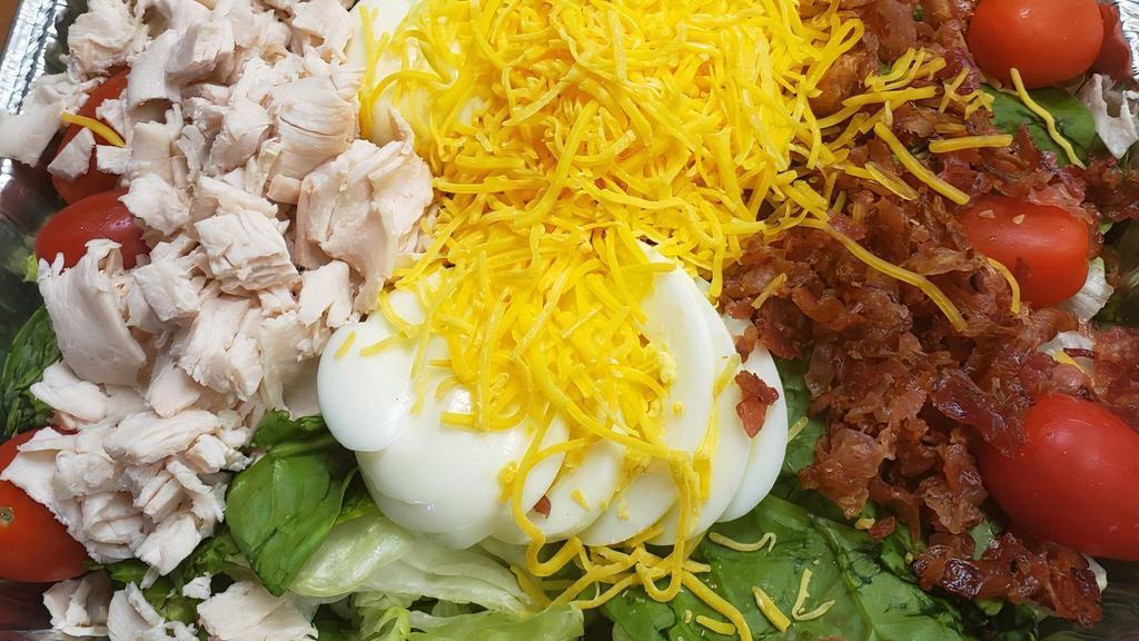 Cobb Salad (Family -Serves 6) · Romaine blend, spinach leaves, turkey, bacon, egg, grape tomatoes & cheddar cheese. Served with raspberry vinaigrette dressing.