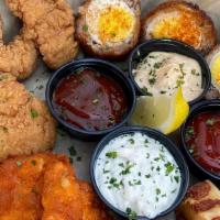Royal Sampler · A regal serving of mac and cheese bites, chicken fingers, cod pieces and scotch eggs.