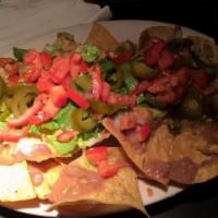 Nachos · Homemade tortilla chips, cheese, refried beans, onions, tomatoes, jalapenos, sour cream, gua...