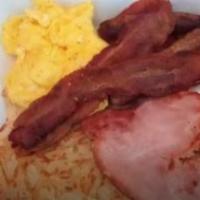 Two Eggs With Bacon Strips · With hash browns or grits, 4 bacon strips, toast and jelly.