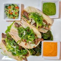 Tacos · Choice of meat, flour tortilla, onions, cilantro, spicy avocado sauce, and house-made slaw.