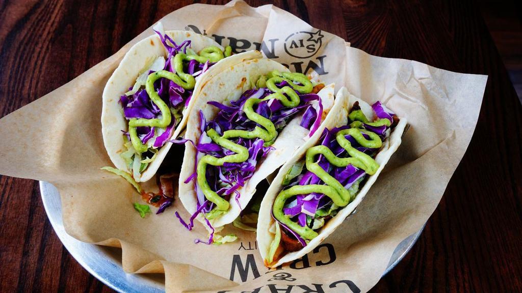 Wild Mushroom Tacos · Garlic-cajun wild mushrooms topped with lettuce, red cabbage, avocado salsa, and green onions