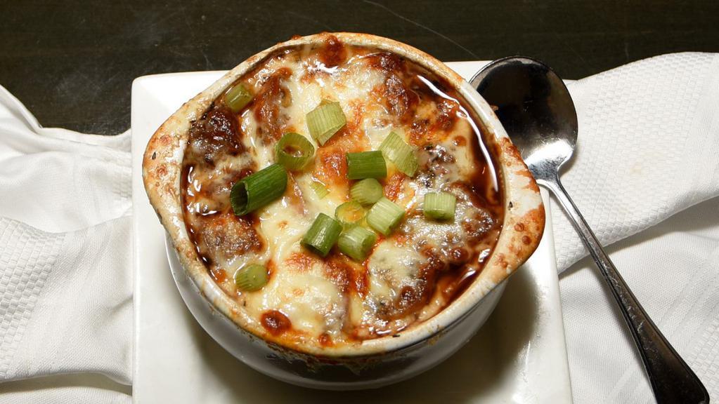 French Onion Soup · Caramelized onions, crostini, Swiss, and Parmesan crust.