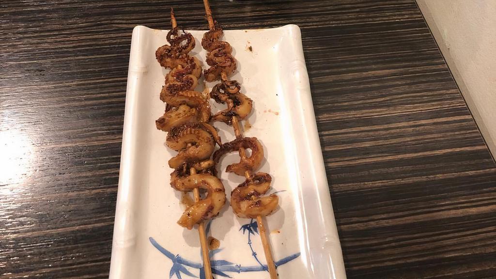 Squid Feet · Grilled squid tentacles on a skewer glazed with bbq sauce and sprinkled with cumin, chili, and seasonings. 2 pieces.