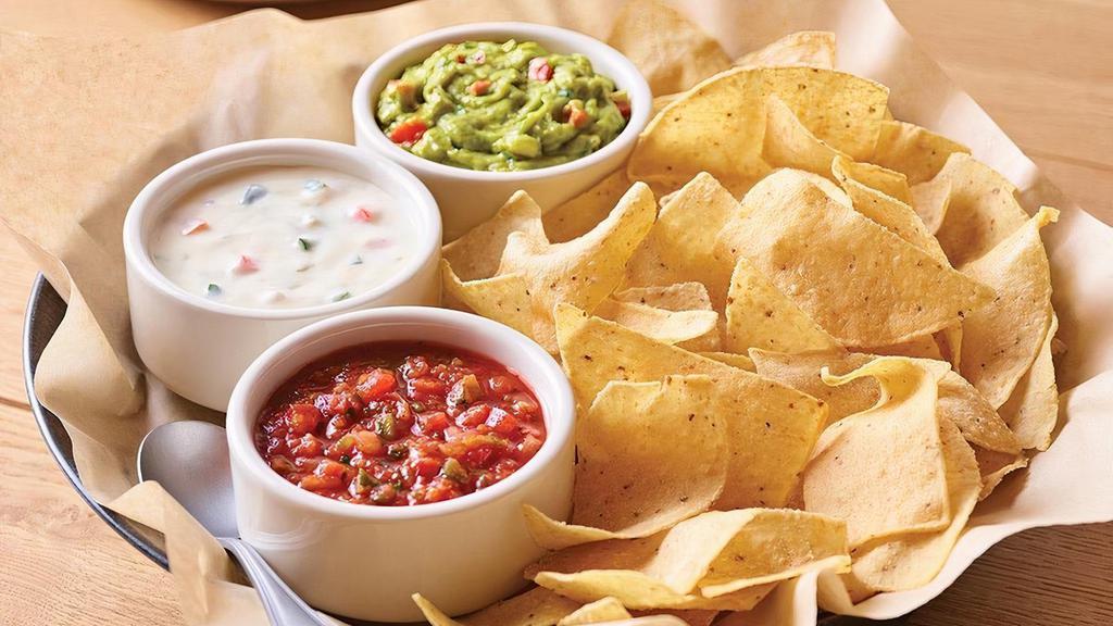 Classic Dip Trio · Freshly made white corn tortilla chips served with our chipotle lime salsa, melty white queso and guacamole.