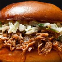 Pulled Pork Sandwich · Tender pulled pork drizzled with our Zesty BBQ sauce topped with house slaw and served on a ...