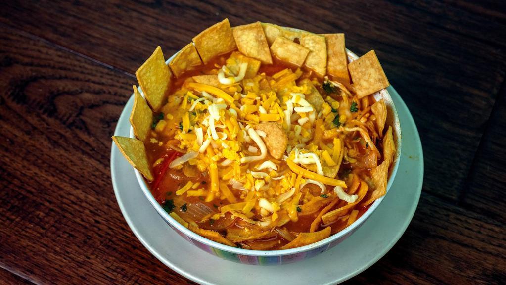 Chicken Tortilla Soup · A delicious soup made to order, consisting of onions, tomatoes, and chunks of shredded chicken. Topped with cheese, crispy tortilla strips and cilantro.
