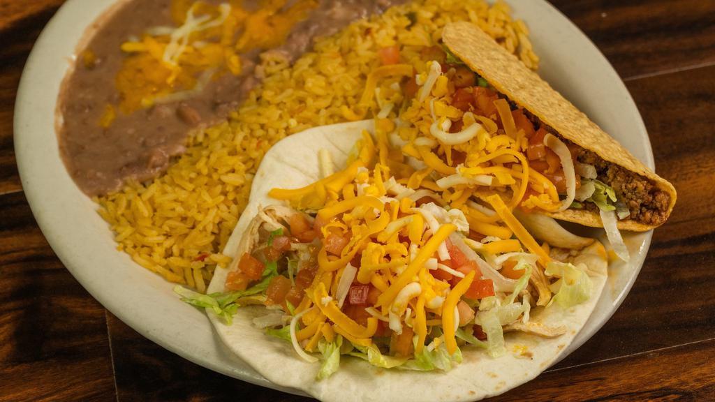 Taco Dinner · Two chicken or beef ground or shredded tacos made in crispy corn shells or soft flour tortillas topped with lettuce, tomatoes, and shredded cheese, served with rice and beans.