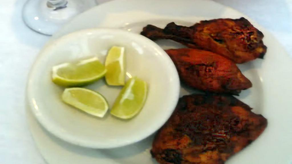 Tandoori Chicken · Marinated chicken skewered and baked in charcoal oven tandoor, served with rice.