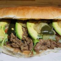 Torta De  Asada · Asada Mexican Sandwich Accompanied with beans, avocado, lettuce, chili pepper slices, tomato...