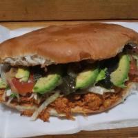 Torta De Tinga · Shredded seasoned chicken Mexican Sandwich Accompanied with beans, avocado, lettuce, chili p...