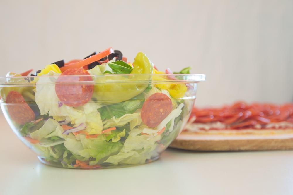 Family Salad · Lettuce, cheese, pepperoni, black olives, tomato, banana peppers and pepperoncinis.