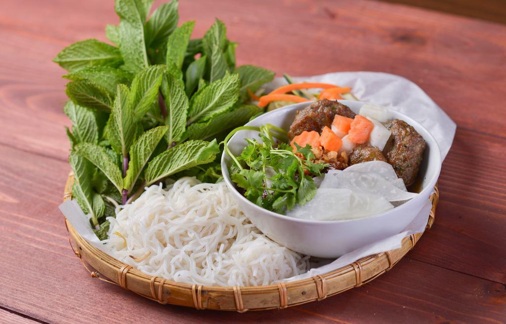 Bun Cha Ha Noi · Seasoned grilled pork patties with thin sliced pork and fried tofu. Served with vermicelli accompanied with pickled daikon/carrots, fresh greens/herbs and chef’s special broth topped with peanuts and green onions.