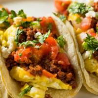 Carnitas Taco · Pork carnitas, cheesy scrambled eggs, avocado, caramelized onions in a taco. Garnished with ...