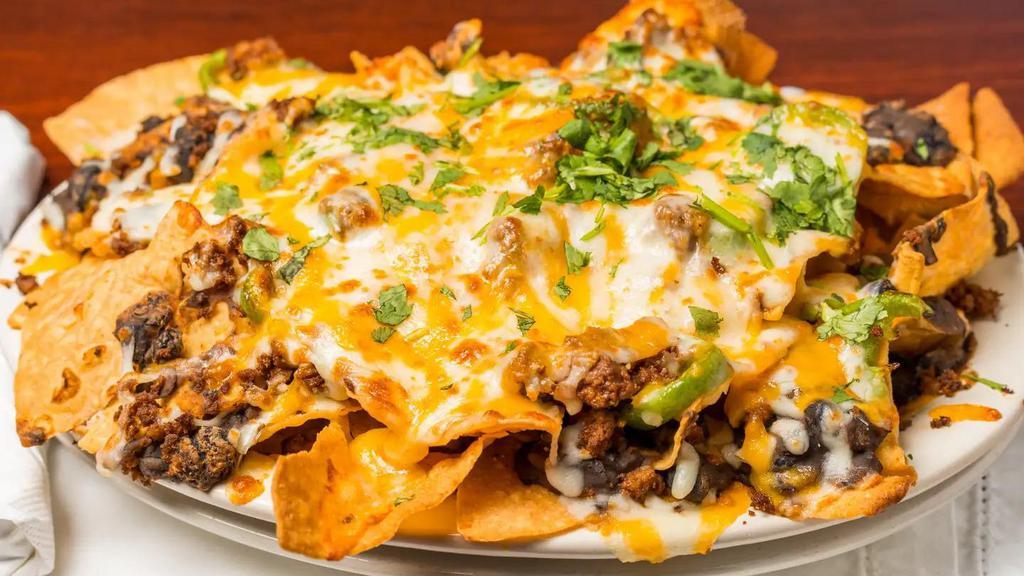 Lighthouse Nachos · Layers of fried tortilla chips, melted shredded cheese, seasoned beef, black beans, jalapenos, cilantro, onions, tomatoes, sour cream and salsa.