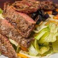 Steak Salad · A bed of fresh lettuce topped with olives, tomatoes and shredded cheese, and a sliced six ou...