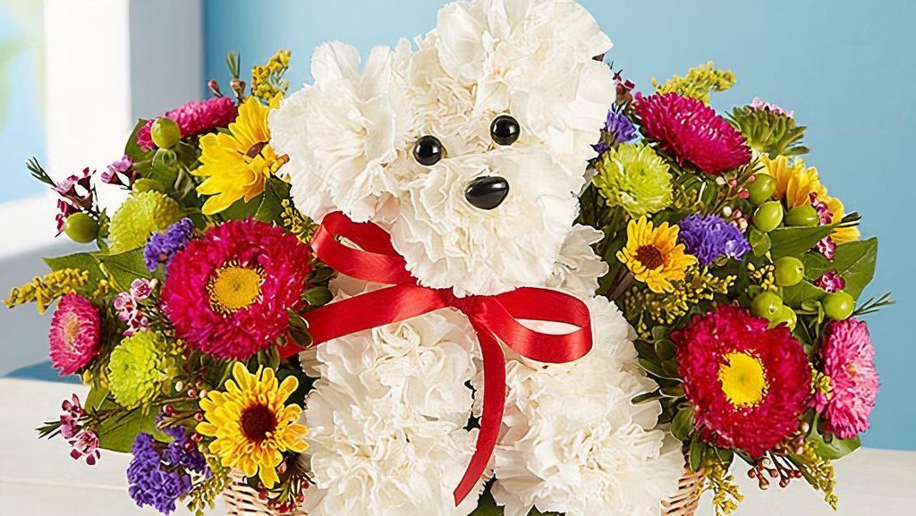 A-Dog-Able In A Basket · Unleash the smiles with our original pup arrangement! Hand-designed inside a basket, this customer favorite floral creation makes a great gift for pet lovers or anyone who could use a little puppy love in their life. 
Artistically designed in a dog bed basket accented with sheet moss; measures 3.5