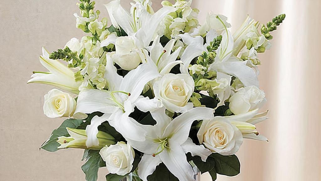 Classic All White Arrangement · Pristine white roses, lilies and snapdragons are hand-gathered by our florists with touches of lush greenery inside a sleek cylinder vase. It’s a classic and comforting gesture that conveys the purity of your sentiment.

Medium arrangement measures approximately 19
