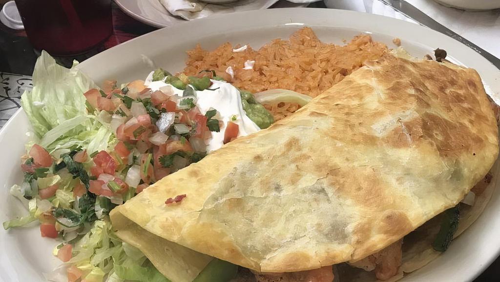 Quesadilla Guadalajara · Large flour tortilla stuffed with cheese, chicken, steak, shrimps, onions, tomatoes, and green peppers. Served with sour cream, guacamole, pico de gallo, rice, and lettuce.