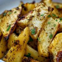 Greek Potatoes · Roasted potato wedges seasoned with lemon, oregano and extra virgin olive oil.