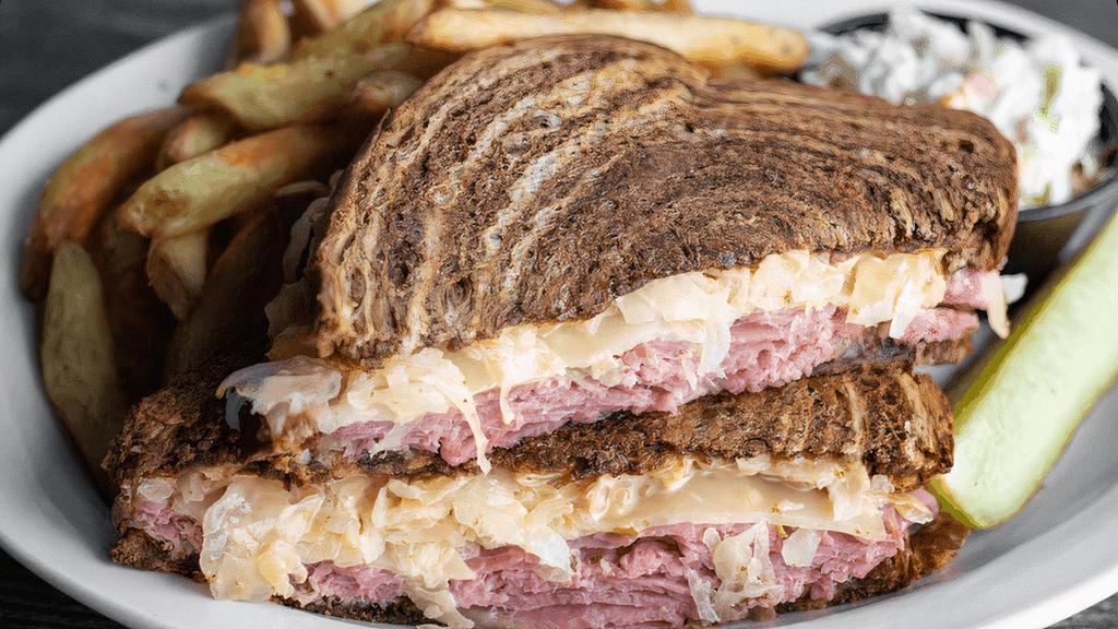 Rustler'S Reuben · Sliced corned beef, sauerkraut, Swiss & Thousand Island on grilled marble rye. Served with coleslaw & fries. (cal 1380)