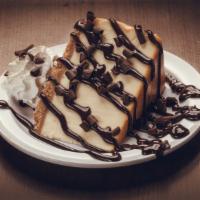 Chocolate Cheesecake · A colossal slice of New York Cheesecake drizzled in chocolate sauce and then topped with sha...