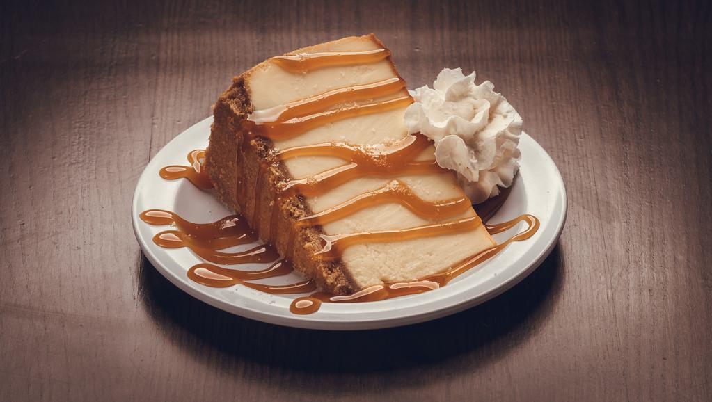 Salted Caramel Cheesecake · A colossal slice of New York Cheesecake topped w/ caramel sauce and sea salt.
