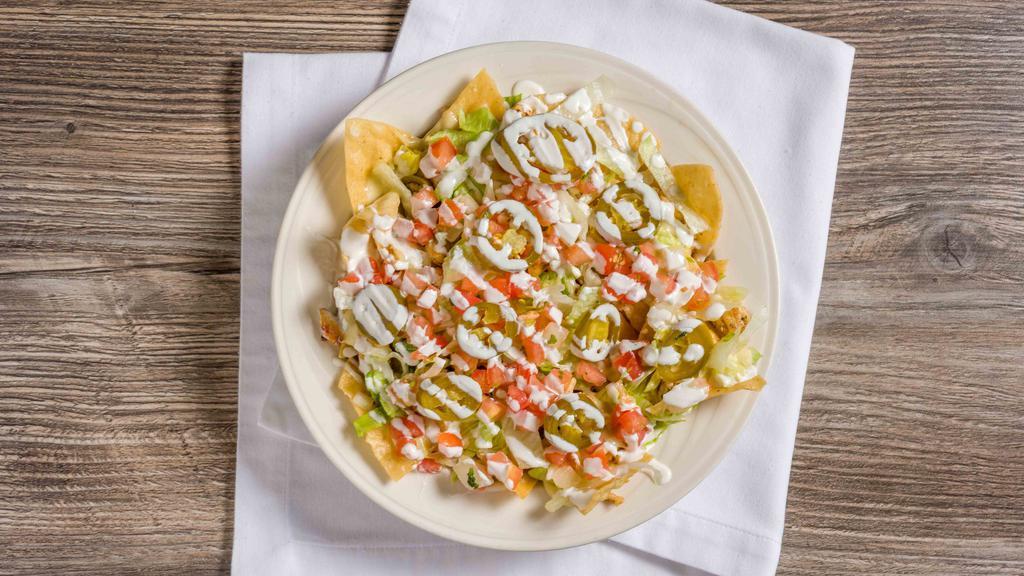 Nachos · Corn tortilla chips topped with your choice of meat, queso, lettuce, pico de gallo, jalapeños, sour cream and guacamole.