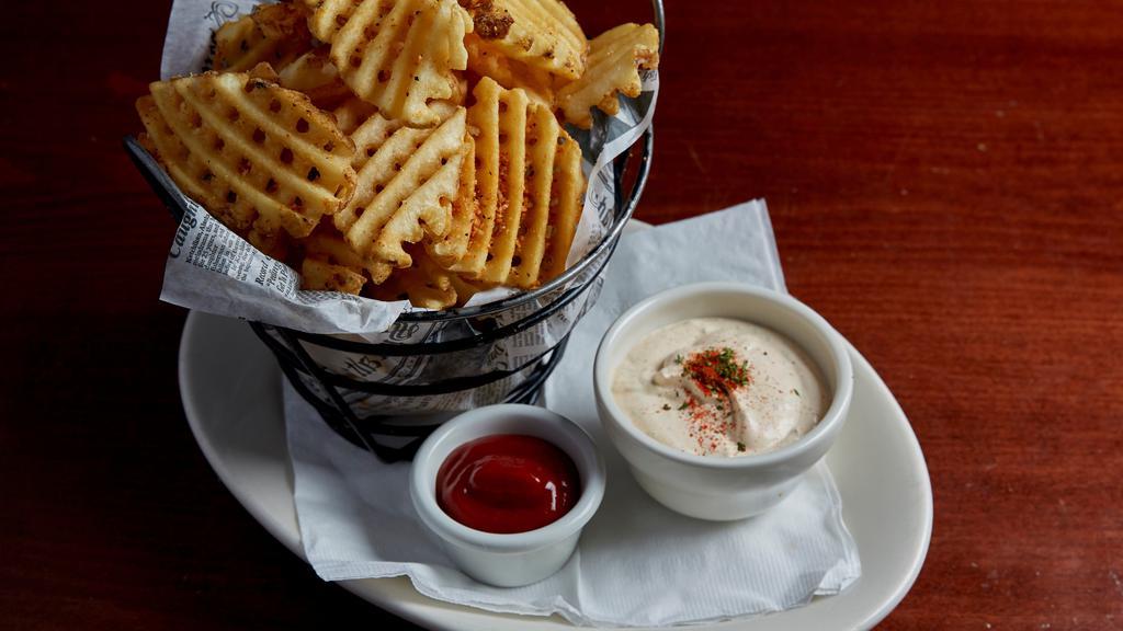Seasoned Waffle Fries · Waffle cut potatoes fried to a golden crisp, dusted with our special blend of parmesan and spices. Served with seasoned sour cream.