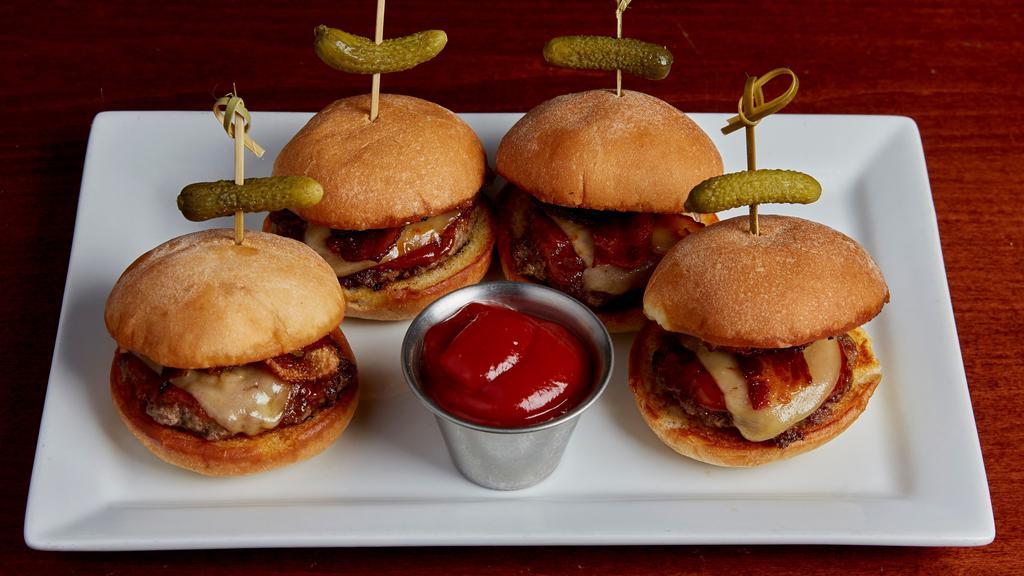 Tavern Style Sliders · Four mini beef burgers grilled then topped with bourbon red BBQ, melted smoked gouda, and crispy smoked bacon. Served on grilled slider buns with speared cornichon.