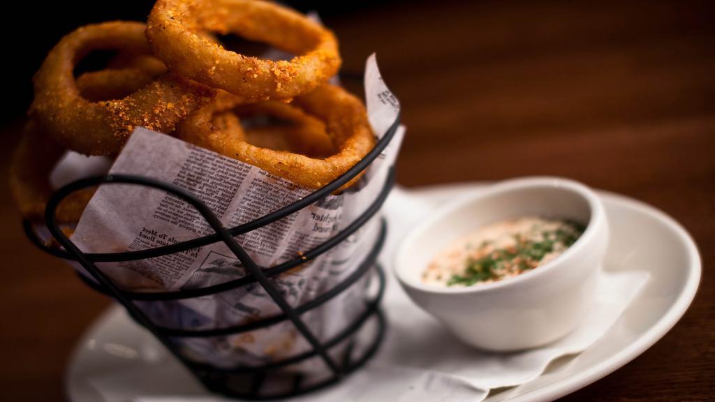 Tavern Onion Rings · Slices of sweet yellow onion dipped in batter and golden fried. Served with seasoned sour cream.