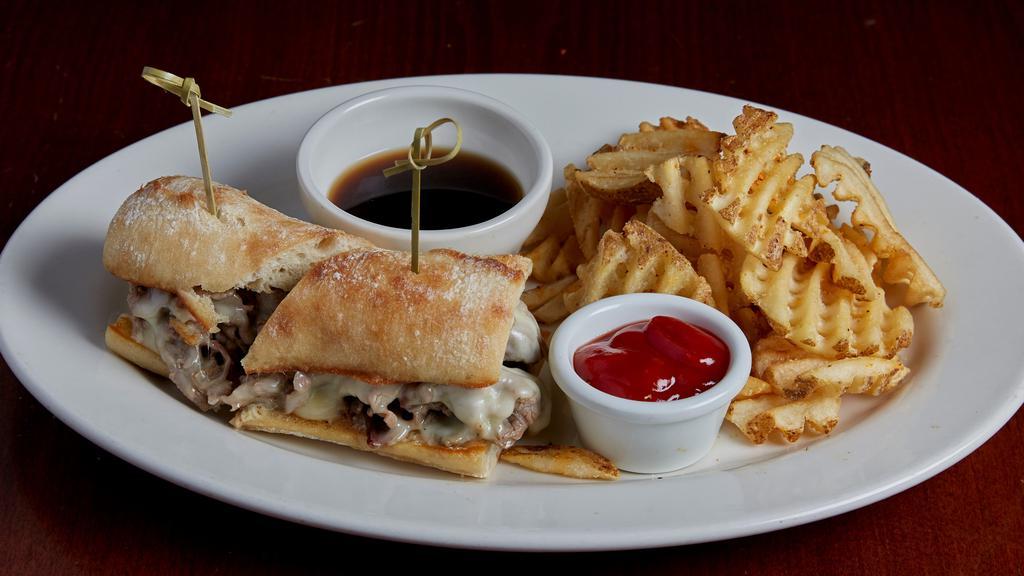 French Dip · Slow roasted beef shaved thin and stacked high on grilled French loaf with melted Monterey jack cheese and garlic aioli. Served with rosemary garlic au jus.