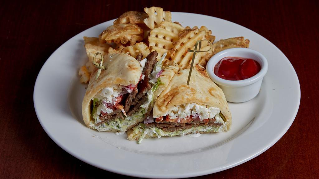 Grilled Gyro On Naan · Lamb beef gyro on warm naan bread with shredded lettuce, tomato, red onion, cucumber planks, feta, and tzatziki sauce.