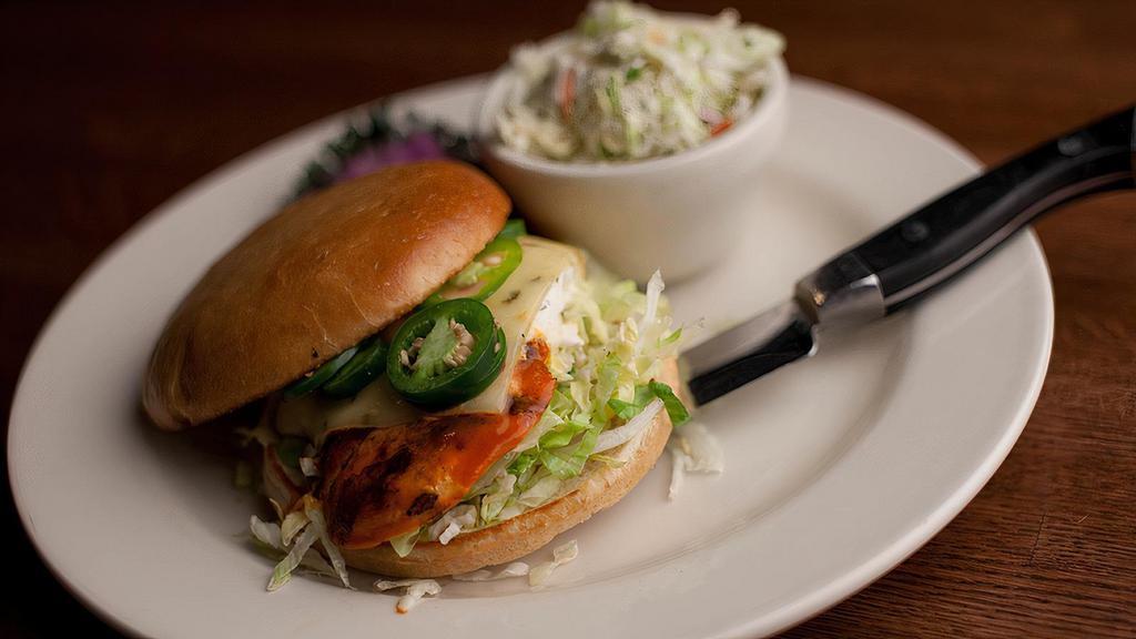Buffalo Chicken Sandwich · Buffalo marinated Chicken breast fire grilled and topped with bleu cheese dressing, melted habanero jack cheese and fresh sliced jalapenos on a grilled stadium bun with shredded lettuce.