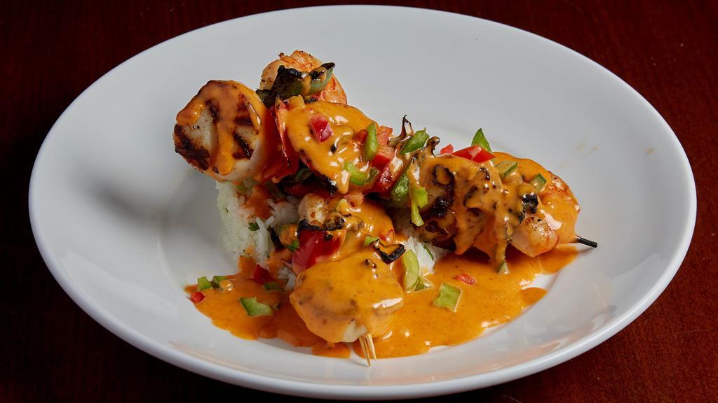 Grilled Shrimp & Scallop Skewer · Jumbo shrimp and scallops, skewered with fresh red onion, green pepper, and red pepper. Charbroiled and served over a bed of cilantro rice with a house made shrimp sauce, diced red and green bell peppers.