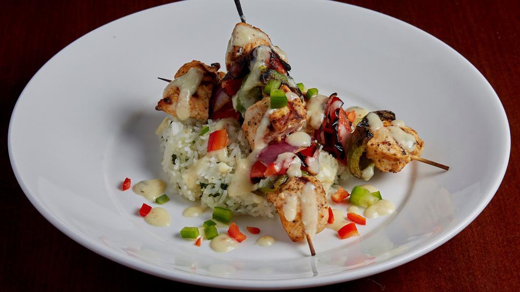 Chicken Skewers · Cilantro lime marinated chicken breast, skewered with fresh red onion, green pepper, and red pepper. Charbroiled and served over bed of rice and topped with house made alfredo sauce, diced red and green bell peppers.