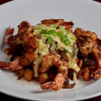 New Orleans Shrimp Tchoupitoulas · Jumbo shrimp skewered, crusted with Cajun spices and charbroiled. Set on a bed of crispy pot...