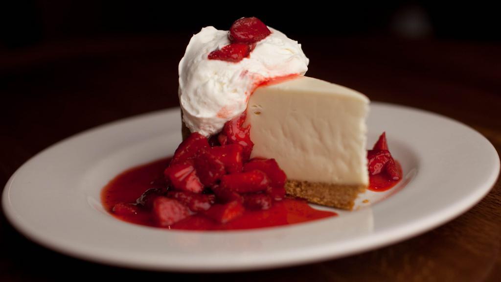 Ny Style Cheese Cake · Accompanied by fresh, sliced strawberries and fresh whipped cream.