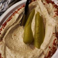 Hummus · Purée of chickpeas, and spices garnished with paprika, and pickles.