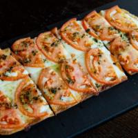Margherita Flatbread · Fresh Mozzarella cheese, thin diced Roma tomatoes, basil and a touch of olive oil.