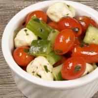 Caprese Salad · Fresh grape tomatoes, cucumber, basil, olive oil and mozzarella.
